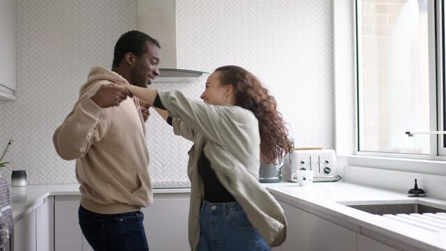 Loving young couple at home dancing in kitchen together - shot in slow motion