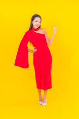 Portrait beautiful young asian woman smile with action on yellow background