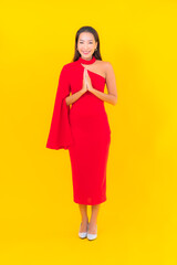 Portrait beautiful young asian woman smile with action on yellow background