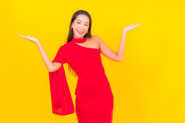 Portrait beautiful young asian woman smile with action on yellow background