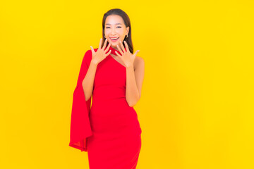 Portrait beautiful young asian woman smile with action on yellow background