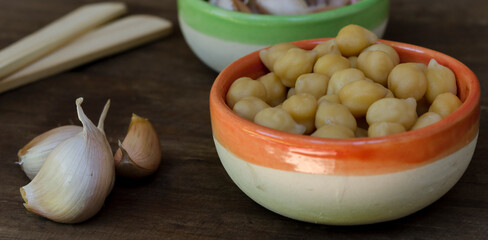 chickpeas in boul to make garlic hummus on natural wooden table