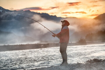 Man fishing at morning sunrise in a mountain river in Alaska, USA - 406878028