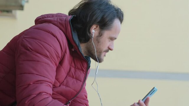 Young man has a video call via smartphone and talks to someone, chat concept