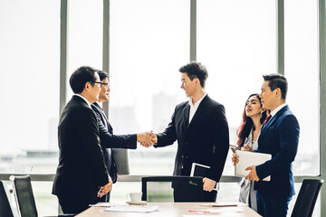 Image two asian business partners successful handshake together in front of group teamwork casual business clapping hands winning success agreement in modern office.Partnership teamwork 