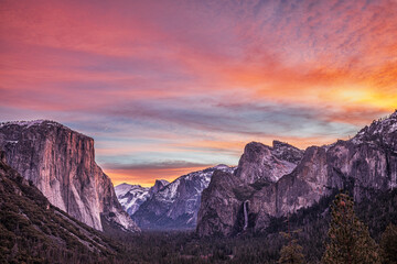 Fototapeta na wymiar Moon rises from misty cloud atop Half Dome in Yosemite National Park at sunset.