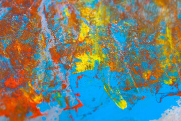 Obraz na płótnie Canvas colorful creative motley background: smudged residues of oil paints on a wooden palette, short focus, selective blur