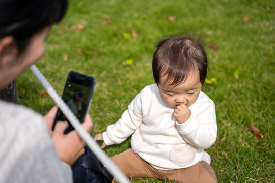 公園で遊ぶ赤ちゃんを撮影するママ（無関心）
