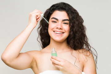 Portrait of a woman putting on moisturizing serum