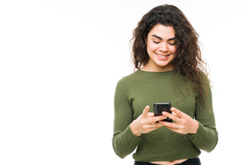 Fototapeta premium Happy woman in her 20s texting on her phone