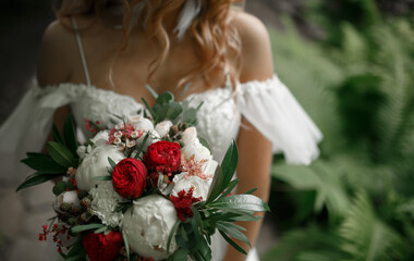 The bouquet is in the hands of the bride.