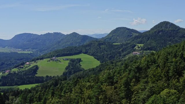 Aerial shot of forest, mountain, and meadow in Lavamünd. Camera pan right