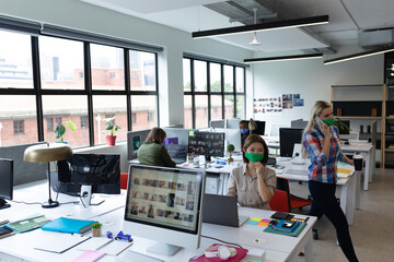Obraz premium Diverse group of business people wearing face masks in creative office