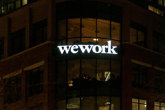 WEWORK's illuminated sign on dark background in Durham, NC USA on January 18, 2021. WEWORK is an American commercial real estate company.