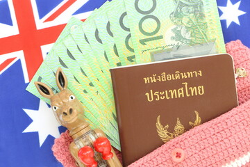 100 Australian green cash money with Thai passport on Australian flag background. Concept travel by yourself ,tour or go to learn at Australia