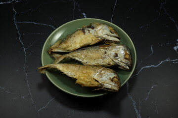Pile of deep fried mackerel fish serving on the plate. 