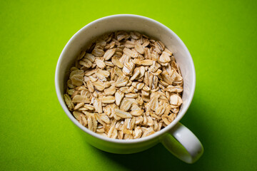 oatmeal inside a white cup with green background
