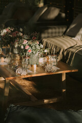 wooden table with personalized glasses, candles and flowers. Decoration for social events.