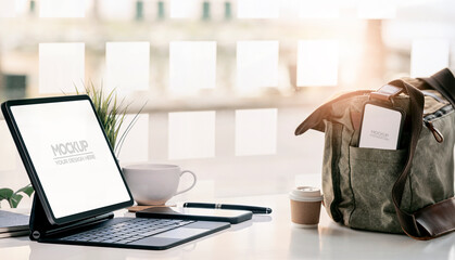 Mockup blank screen tablet on the table and blank screen smartphone in shoulder bag. Working online concept.