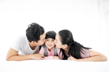 Happy asian family people leisure in bedroom together. Father and mother with daughter relaxing on bed and enjoy funny