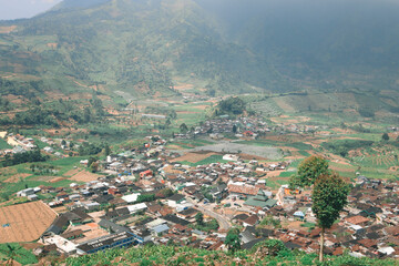 Aerial view of Dieng Plateau with town and hill in background