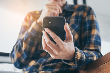 using cell phone hand holding mobile texting message contact us.chatting,search internet information in office.technology device communication connecting