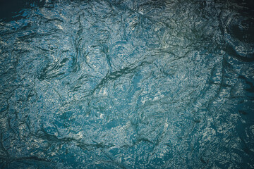 Texture of dark blue calm water of lake. Meditative ripples on water surface. Nature minimal background of deep green lake. Natural backdrop of clear dark turquoise water. Full frame of lake fragment.