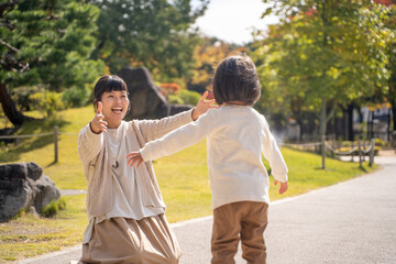 Obraz premium 秋の公園で遊ぶママと子供 