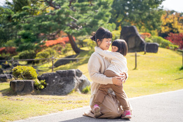 Fototapeta premium 秋の公園で遊ぶママと子供 