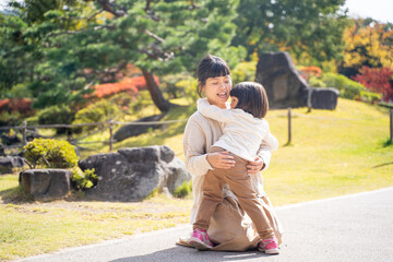 Fototapeta premium 秋の公園で遊ぶママと子供 