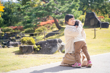 Fototapeta premium 秋の公園で遊ぶママと子供 