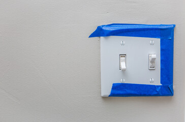 Light switch with blue painter's tape around it