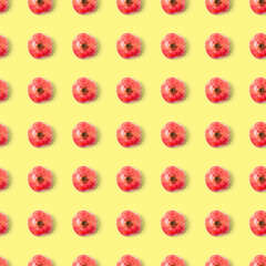 Seamless pattern with red pomegranate fruit on yellow background. Minimal flat lay concept.