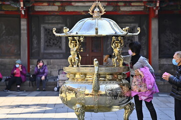 Longshan Temple, Taipei, Taiwan - January 15, 2021: the worshipper hover their amulet over the...