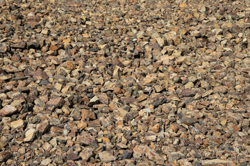 Crushed mountain stones on the ground texture background in the image.
