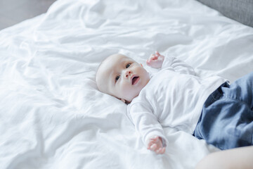 Cute baby on white bed. Baby, newborn concept.