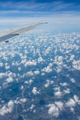 view from airplane window ground below clouds wing wing flaps