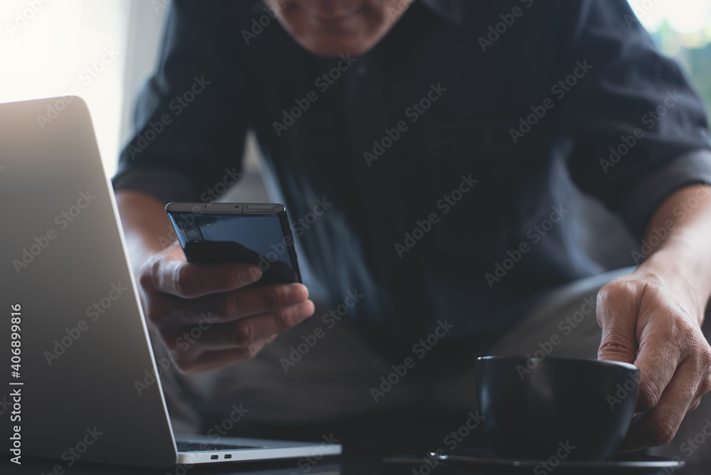 Poster work from home concept. man using mobile phone and drinking coffee during working on laptop computer