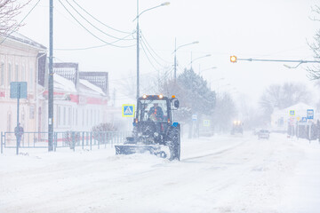 Removing snow from the highway during a snowstorm