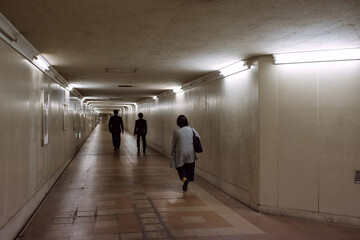 People walking in dark underground passage　暗い地下道を歩く人々