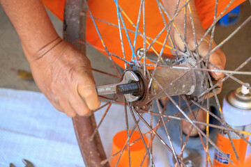 Fototapeta na wymiar Close up of human hand, using a repair tool on the wheel.