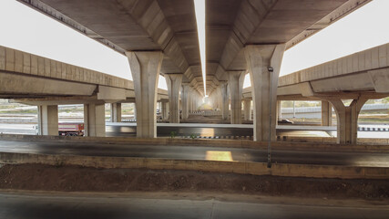 Under highway bridge. View of  the concrete pillars straight line.