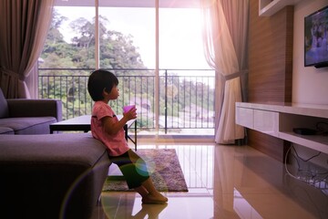 an asian girl is watching television in the living room alone