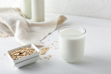 Glass of tasty oat milk on table