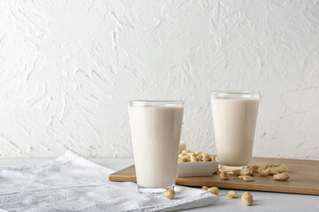 Glasses of different vegan milk on light background