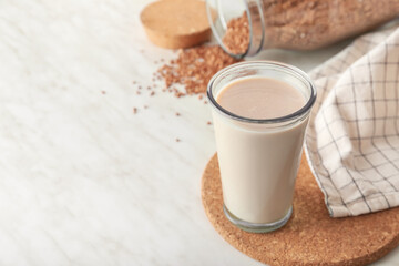 Glass of tasty buckwheat milk on table