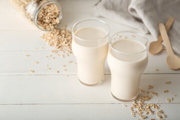 Glasses of tasty oat milk on table