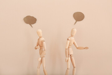 Wooden mannequins with empty speech bubbles on color background