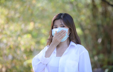 Corona virus, or Covid-19, is spreading all over the world. Business women Sit in the park wear...