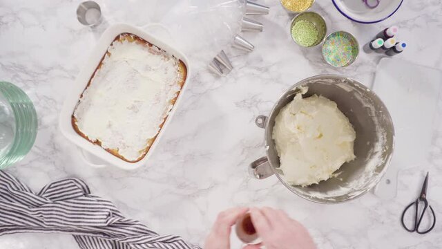 Time lapse. Flat lay. Piping rosettes with Italian buttercream frosting on top of sheet cake.